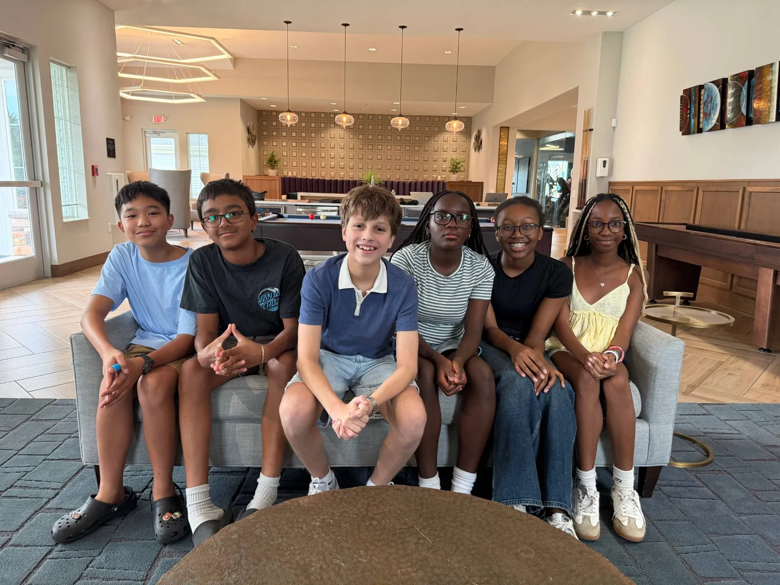 Six members of the Algebridge team sitting together on a couch in a lounge